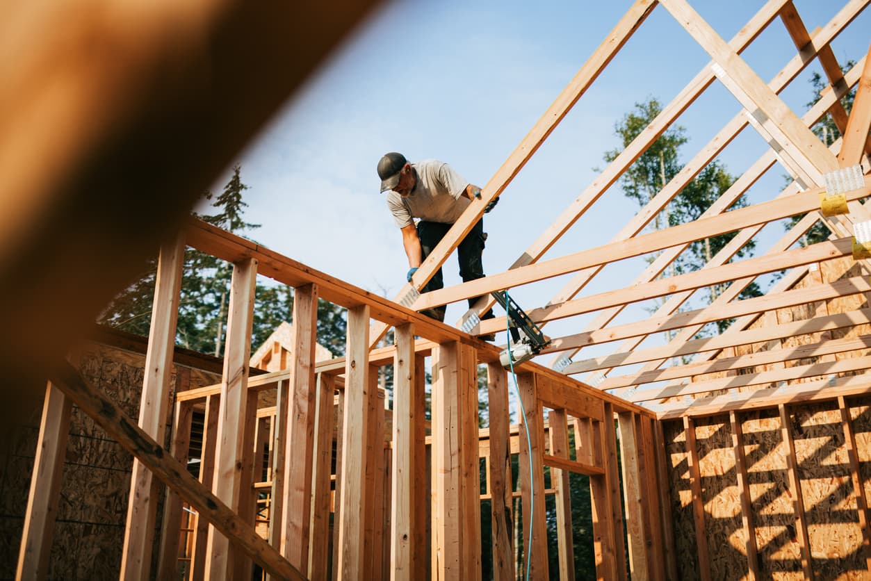 Builder working on frame of house thanks to construction loan